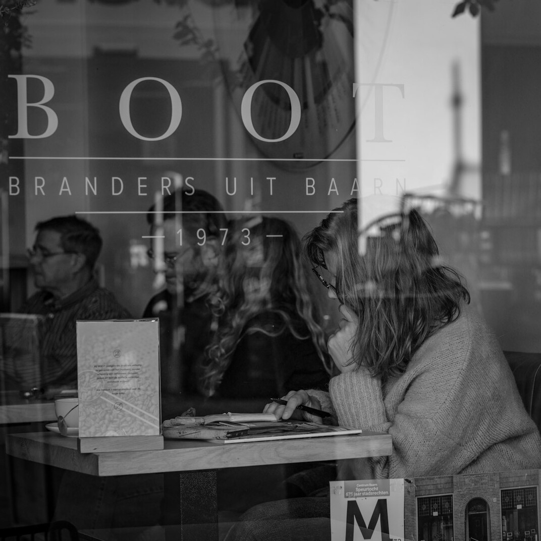 Two friends reading a mystery book together in a cafe