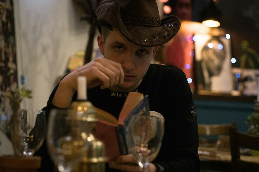 Young woman reading a mystery paperback with a magnifying glass